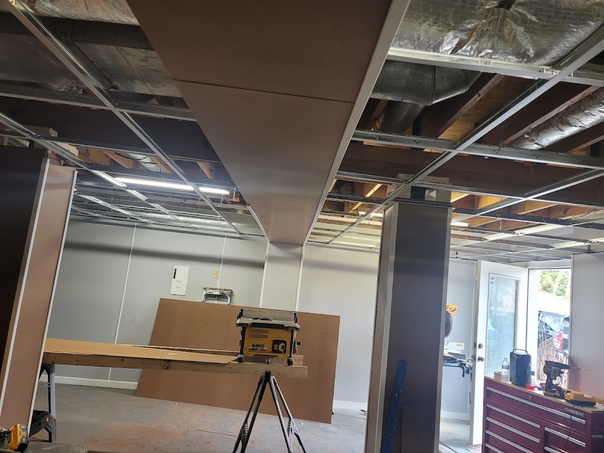 Ceiling framing and drop-ceiling grid installed during a basement build-out