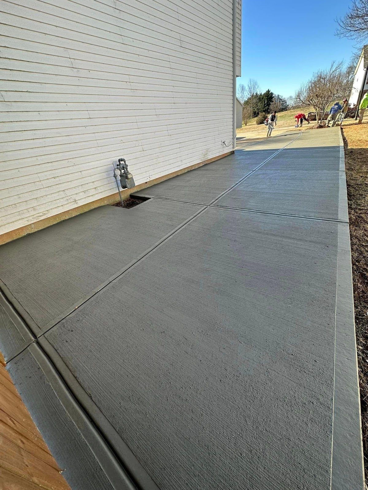 Freshly poured broom-finished concrete driveway by Wise Construction Group